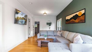 A modern living room with a sectional sofa, a coffee table, and artwork on the walls.