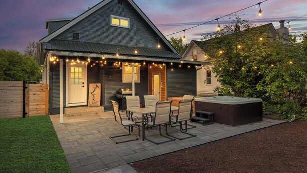 A house with a patio, outdoor seating, and a hot tub.