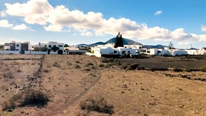 A rural landscape with white buildings, a dirt path, and sparse vegetation. - Apartment Alegranza in the Beautiful Village of Mozaga, Lanzarote (Teguise)