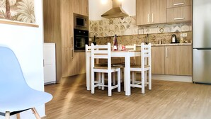 A modern kitchen with wooden cabinets, a white dining table, and a stainless steel refrigerator. - Apartment Alegranza in the Beautiful Village of Mozaga, Lanzarote (Teguise)