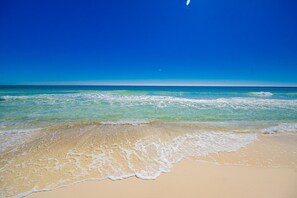 Una playa con aguas azules cristalinas y una orilla arenosa.