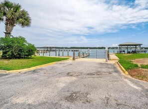 A gated entrance to a waterfront area with a gazebo and a palm tree. - Sea Oats 105h 3 Bedroom Condo (Gulf Shores)