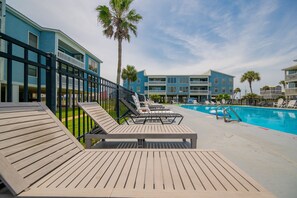 Un espace aménagé au bord de la piscine, avec des chaises longues et une piscine.