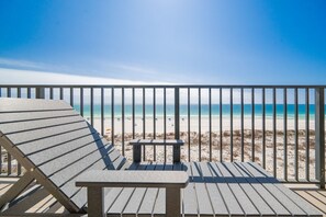 A beach view from a balcony with a railing, a bench, and a lounge chair. - Phoenix X 506 3 Bedroom Condo (Orange Beach)