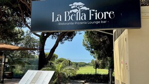 A sign for La Bella Fiore, a restaurant and lounge bar, with a menu board in front. - Spacious 1-Bedroom Apartment with Private Rooftop & Sunny Terrace (Quarteira)