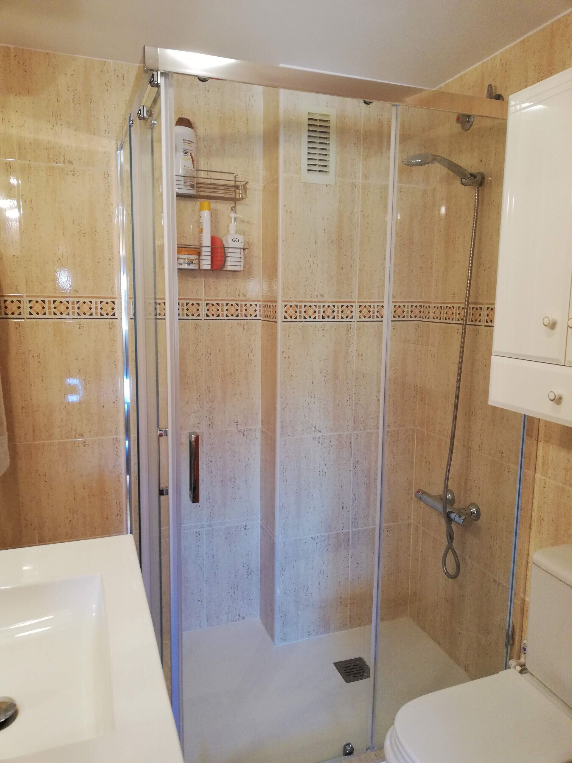 Ein Badezimmer mit Duschkabine, Toilette und Waschbecken.