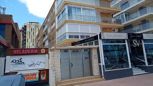Ein mehrstöckiges Gebäude mit einem Burger King Schild, einem 'Heladería' Schild und einem Geschäft namens 'Calzados SV'.
