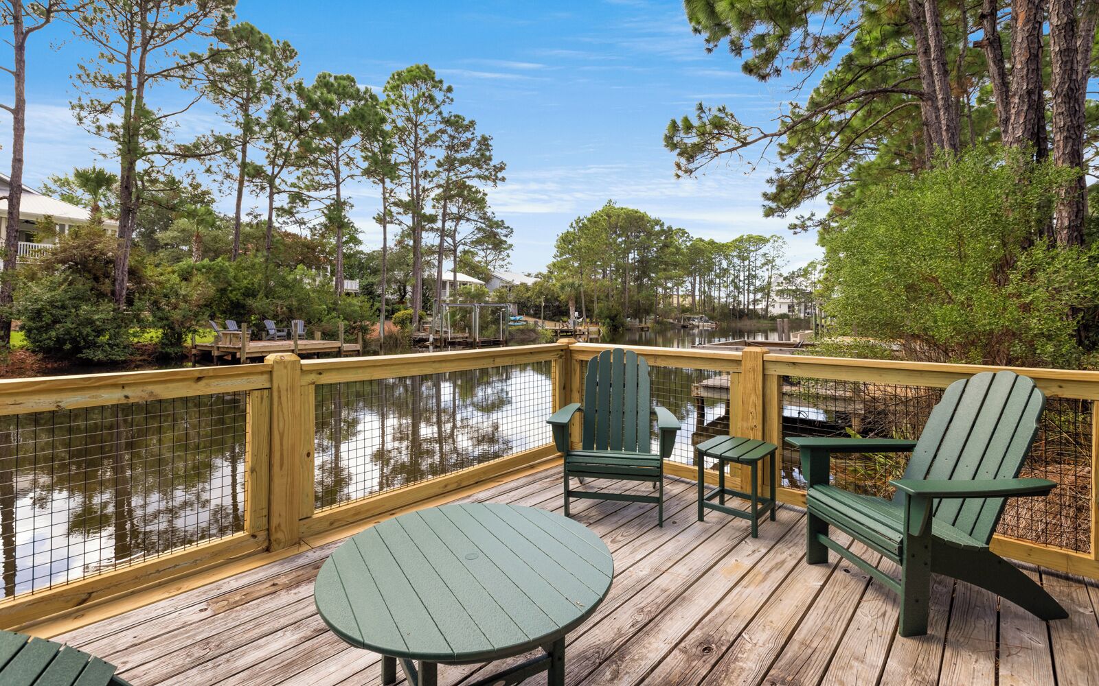 Une terrasse en bois offrant une vue sur un lac, entourée d’arbres.
