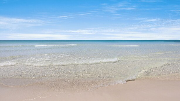 A beach with clear shallow waters and a sandy shore. - Lakefront Home + Dock, Screened Patio, & Bikes (Santa Rosa Beach)