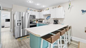 A modern kitchen with a central island, stainless steel appliances, and white cabinetry. - Fall 2026 Rate Drop! 2BR/2BA - Great Location! Book Now! (Port St. Joe)