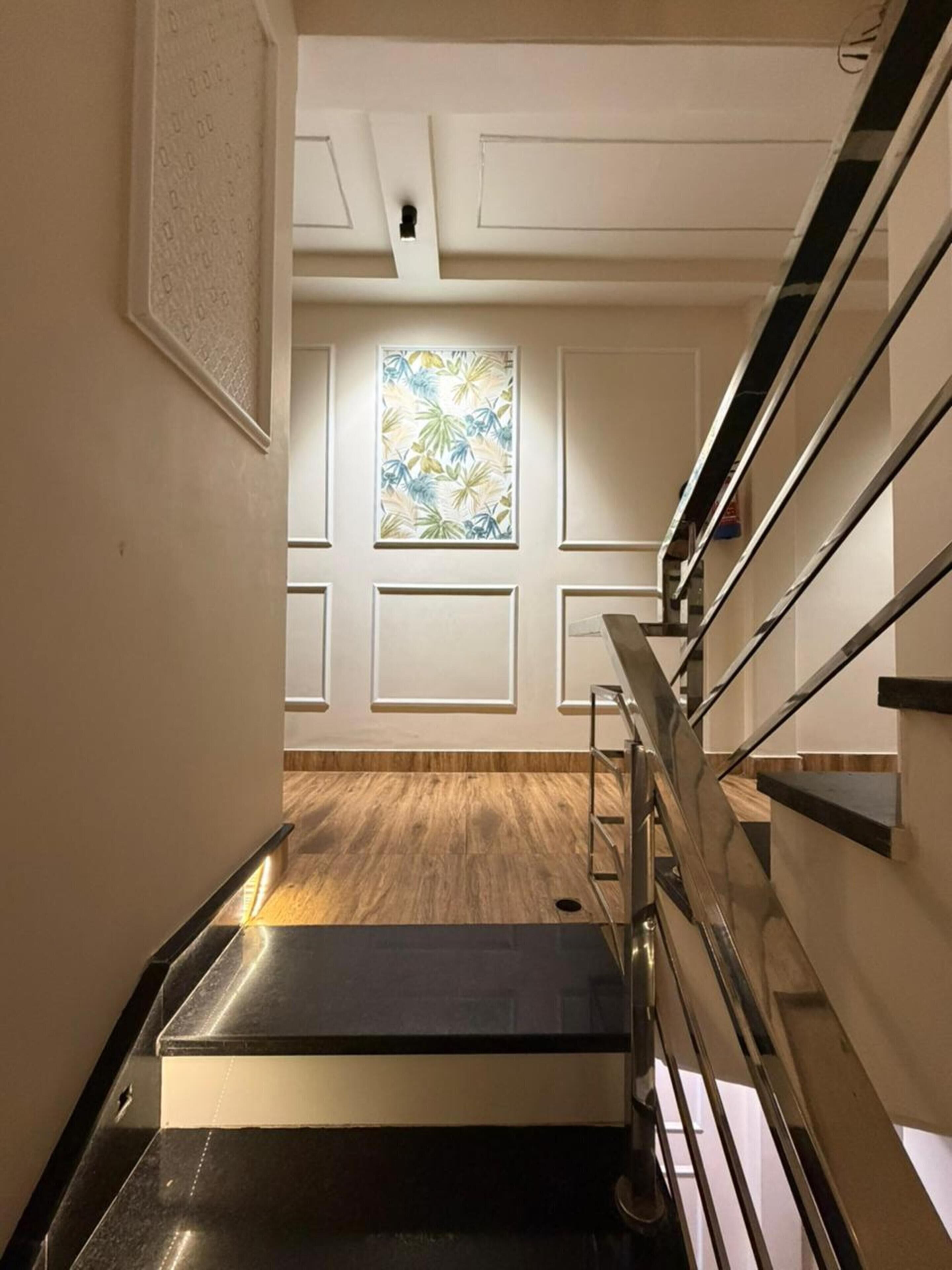 Eine moderne Treppe mit Holzboden, weißen Wänden und einem Buntglasfenster.