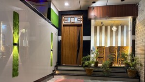 A hotel entrance with a wooden door, potted plants, and a patterned floor. - Hotel Lotus Inn (Varanasi)