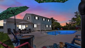 Ein Garten mit Pool, Terrassenmöbeln und einem Haus.