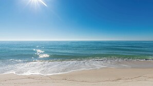 A beach with clear skies and sunlight reflecting on the water. - Phoenix X506  Feel the Sea Breeze (Orange Beach)