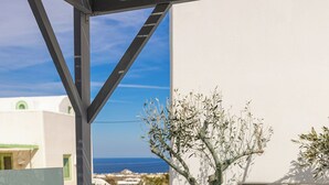 A modern outdoor hot tub with a clear view of the sea and a white building in the background. - New Lux Misilia Suite & Prive Jacuzzi (Santorini)