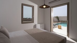 Une chambre avec un grand lit, une fenêtre et une vue sur une piscine à l’extérieur.