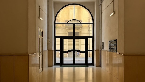 A hallway with a large arched doorway leading to a building with classical architecture. - CASA RUGGI COZY HOUSE 5 MINUTES FROM NAPLES CENTRAL STATION (Napoli)