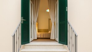 A staircase leading to a bedroom with green shutters and a bed. - CASA RUGGI COZY HOUSE 5 MINUTES FROM NAPLES CENTRAL STATION (Napoli)