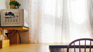 Una habitación con una mesa de madera, una silla, una planta pequeña y un aire acondicionado instalado en la pared.