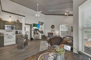 A spacious living area with a kitchen, dining table, and a comfortable seating area.