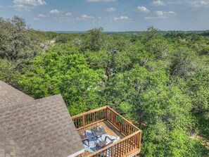 A balcony with a view of dense green foliage.