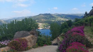 A paved pathway leading to a scenic overlook with a view of a lake and distant hills.