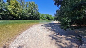 A gravel path beside a clear river, surrounded by dense green trees. - Castle 15mn Toulouse Pyrénées' view and pool (Clermont-le-Fort)