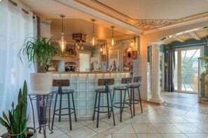 A bar area with stools, pendant lighting, and a decorative ceiling. - Villa Le Rossignol - Vacation Home for 10 People ⭐️⭐️⭐️⭐️⭐️ (Puimisson)