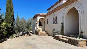 Un edificio de estilo mediterráneo tradicional con un patio, escalones de piedra y arcos.
