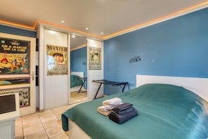 A bedroom with a bed, a green blanket, and two posters on the wall. - Villa Le Rossignol - Vacation Rental for 10 People ⭐️⭐️⭐️⭐️⭐️ (Puimisson)