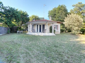 Enjoy a peaceful stay in this single-story home surrounded by a well-maintained lawn and patio area.