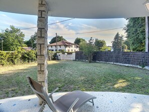 Relax in a serene outdoor space with a comfortable lounge chair and a view of a nearby house.