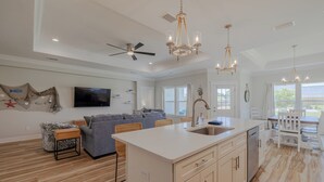 A spacious kitchen with a large island, wooden flooring, and modern appliances.