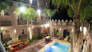 A courtyard with a swimming pool, outdoor seating, and palm trees. - riad rayhana de l atlas  (Ourika)