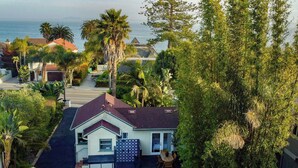 A residential property with a patio, outdoor seating, a swimming pool, and a view of the ocean. - The Captain's Cottage on Shoreline Drive (Santa Barbara)