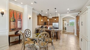 A spacious kitchen with wooden cabinets, a central island, and pendant lighting.