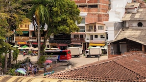A town with a prominent white church, terracotta-roofed buildings, and a palm tree. - Hotel Plaza Centro Cocorná (Cocorná)
