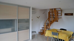A dining area with a yellow table, chairs, and a wooden staircase. - RENTAL CONCARNEAU LE CABELLOU 80 M FROM THE BEACH (Concarneau)