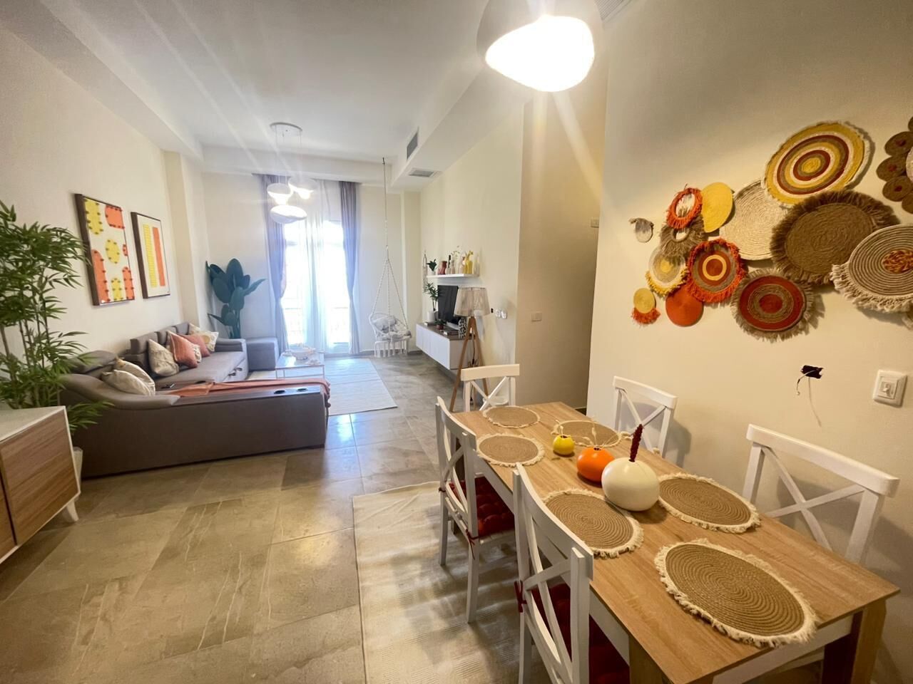 A modern living room with a sofa, dining table, and decorative wall art.