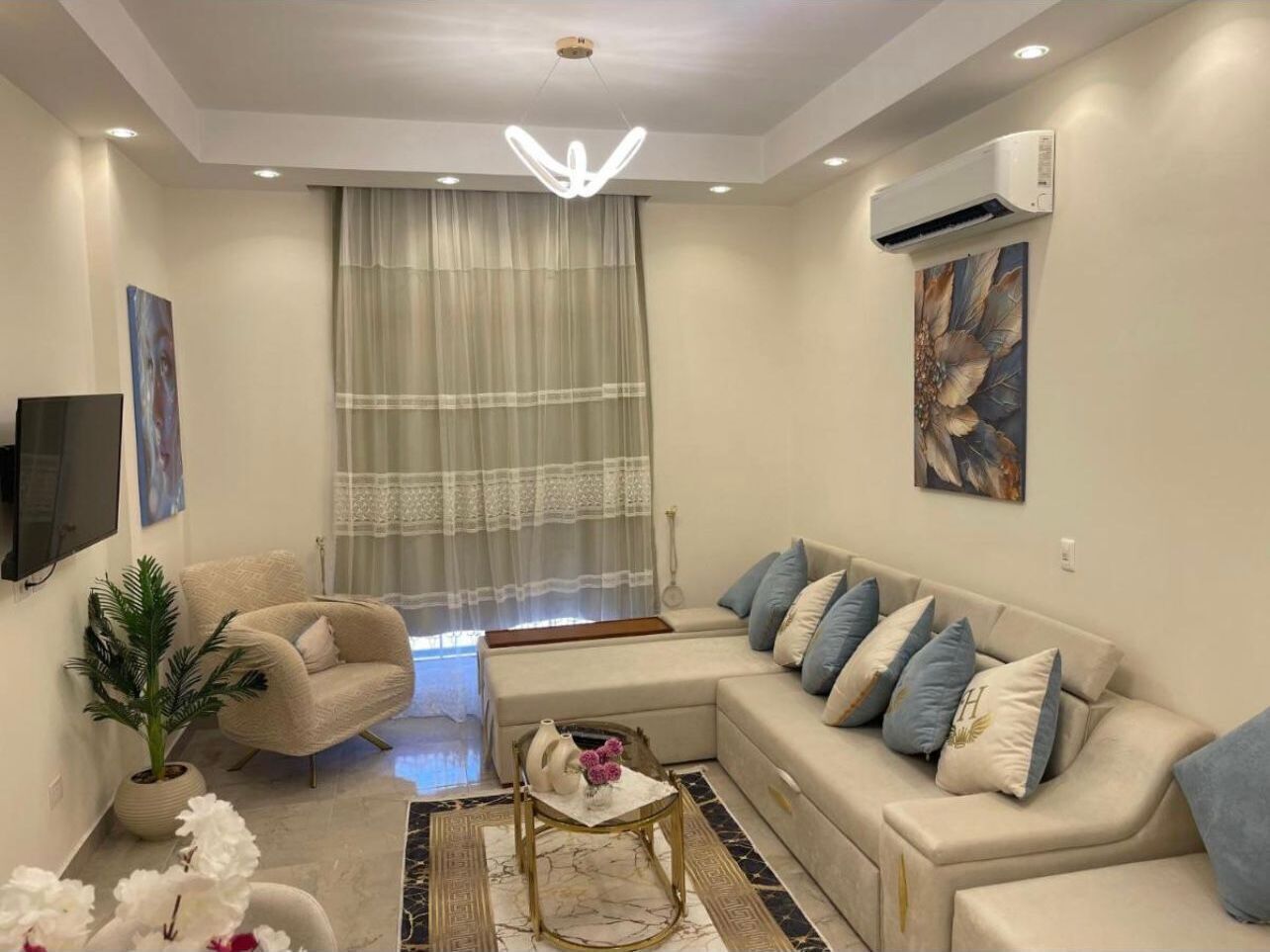 Una sala moderna con sofá, sillón y una mesa de centro.