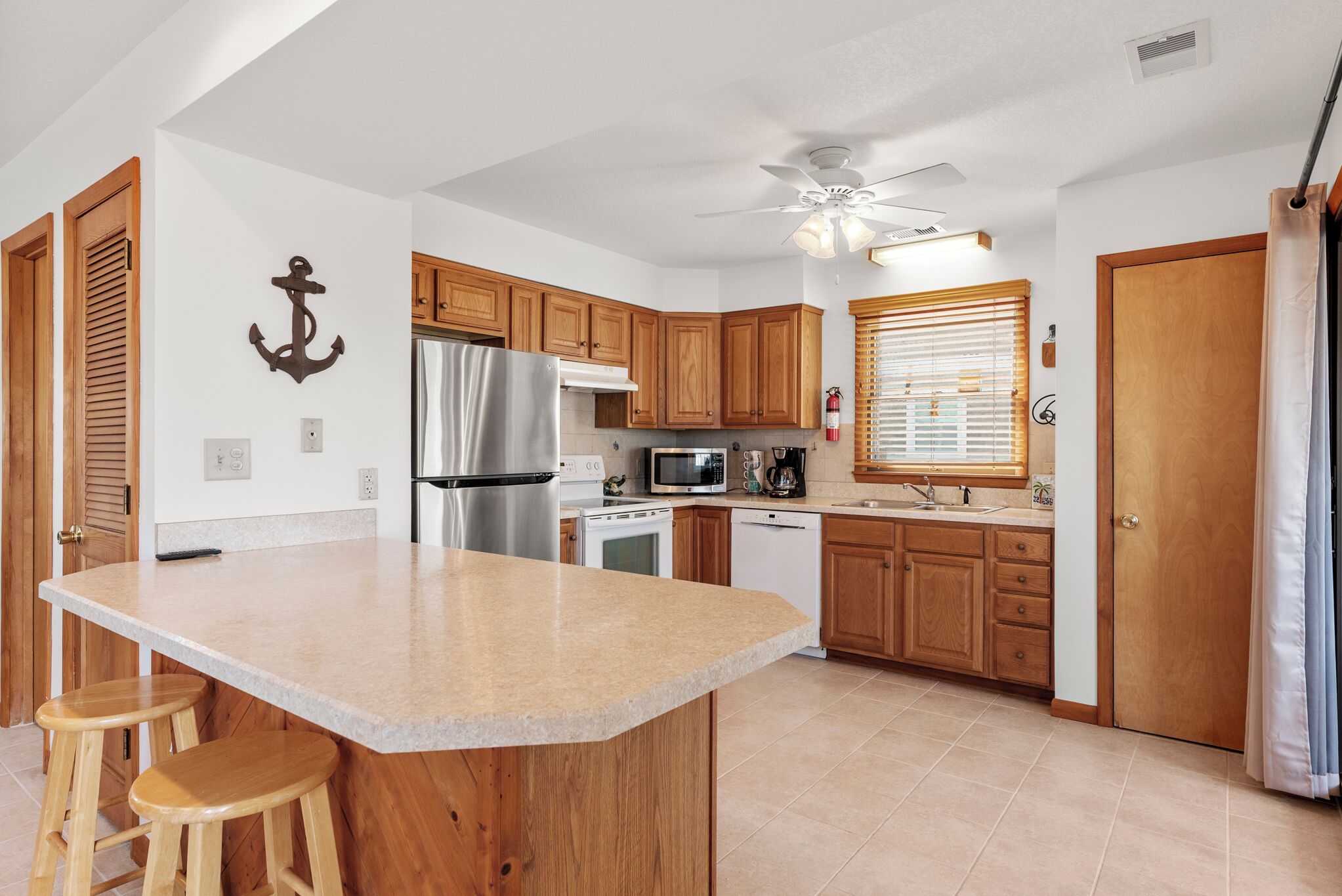 A kitchen with wooden cabinets, a stainless steel refrigerator, a microwave, and a dishwasher.