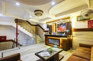 A hotel lobby with a reception desk, a staircase, and a seating area. - Hotel Vinayak -Banganga Road Katra  (Reasi)