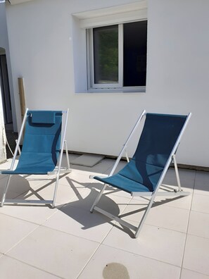 Two blue lounge chairs with metal frames on a tiled patio. - Quiet T1 in St Marc sur Mer, 5 min walk to the beach, terrace and large bed! (Saint-Nazaire)