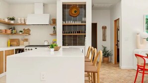 A modern kitchen with a central island, wooden cabinets, and a built-in stove. - Lake Austin Luxury/200ft Private Waterfront on 2 Acres/2 Docks/Sleeps 4 (Austin)