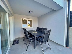 Un espace repas comprenant une table, des chaises, une fenêtre et une porte.
