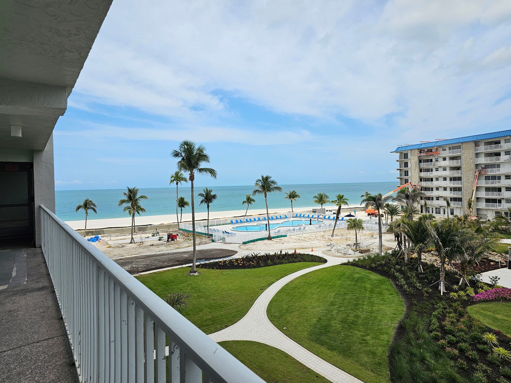 Um resort com piscina, praia e palmeiras.