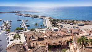 A coastal town with a marina, traditional Mediterranean architecture, and a clear view of the sea. - Belgravia Club Townhouse Estepona by Mabiente Properties (Estepona)