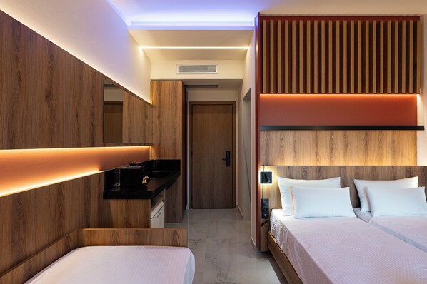 Una habitación de hotel moderna con una pared decorativa de madera, un escritorio empotrado, una cama con ropa blanca y un teléfono montado en la pared.