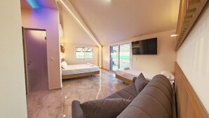 Une chambre d’hôtel moderne dotée d’un grand lit, d’un canapé, d’une télévision et d’un balcon avec vue.