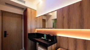 Une salle de bain moderne avec un meuble-lavabo en bois, un miroir et un petit réfrigérateur.